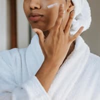 Frau cremt sich das Gesicht ein Frau cremt sich das Gesicht ein