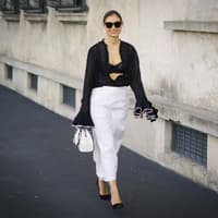 Kontrast-Core ist der edelste Modetrend im Sommer 2024 Frau trägt weißen Rock und schwarze Bluse