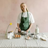 Frau mit grüner Schürze backt Kuchen