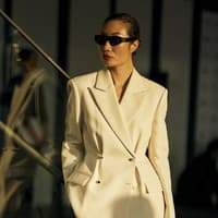 Frau in cremefarbenen Hosenanzug Frau in cremefarbenen Hosenanzug