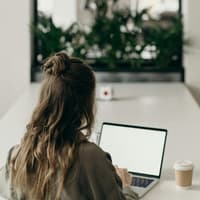 Frau sitzt vor ihrem Laptop