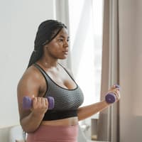 Frau macht "Cozy Cardio" mit Hanteln