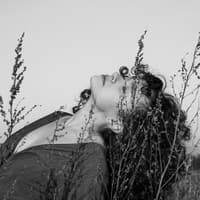 Frau mit Locken liegt in einem Feld