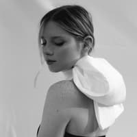 Frau trägt weiße Schleife um den Hals