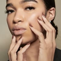 Frau trägt braunen Nagellack