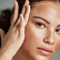 Frau schaut ihr Gesicht an