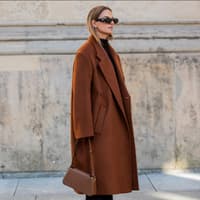  Frau trägt braunen Wollmantel mit brauner Tasche