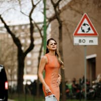 Dieser Minimizer für eine große Oberweite ist der Sommer-Hit Frau in orangefarbenem Kleid