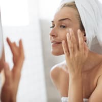 Ältere Dame trägt Augencreme auf