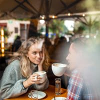 Erstes Date Körpersprache Mann und Frau sitzen sich gegenüber und trinken Kaffee