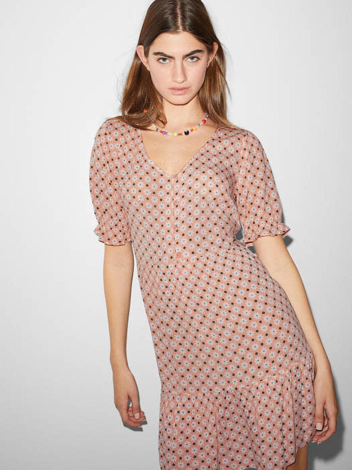 Frau in einem geblümtem Kleid mit Volants