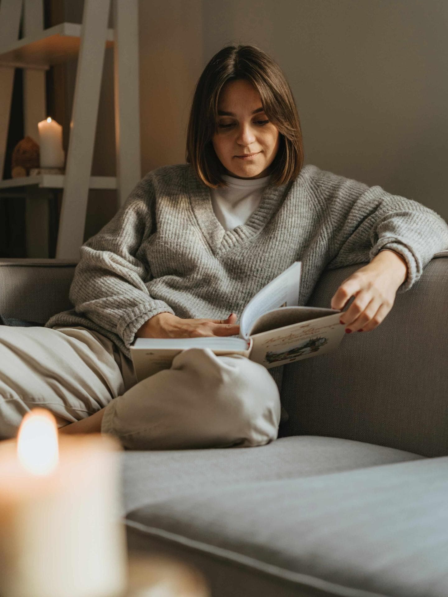 Frau sitzt auf Sofa und liest