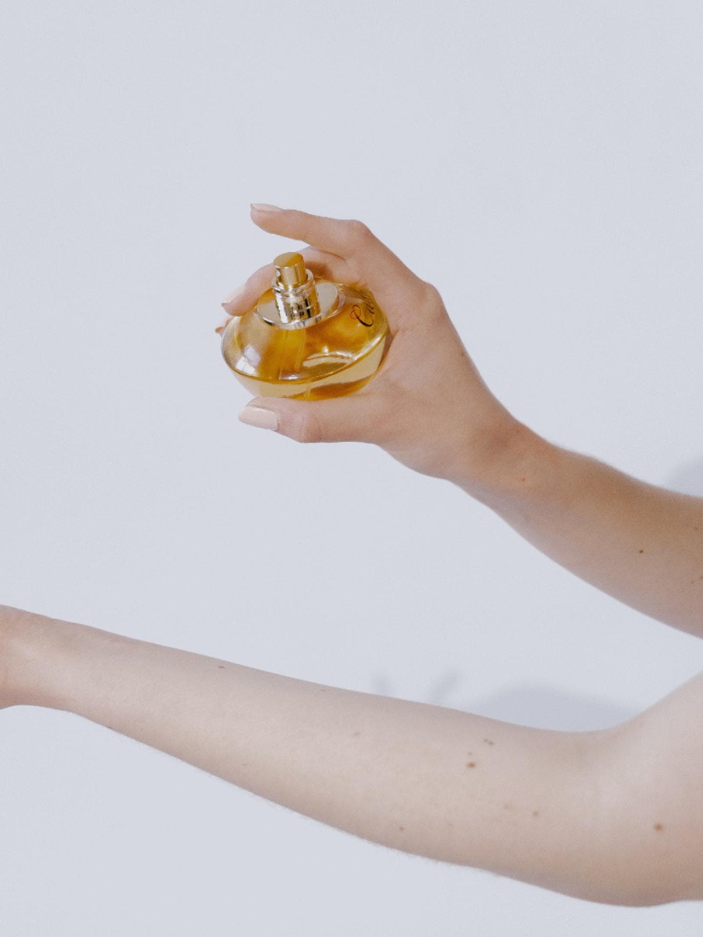 Frau sprüht sich mit Parfum ein 