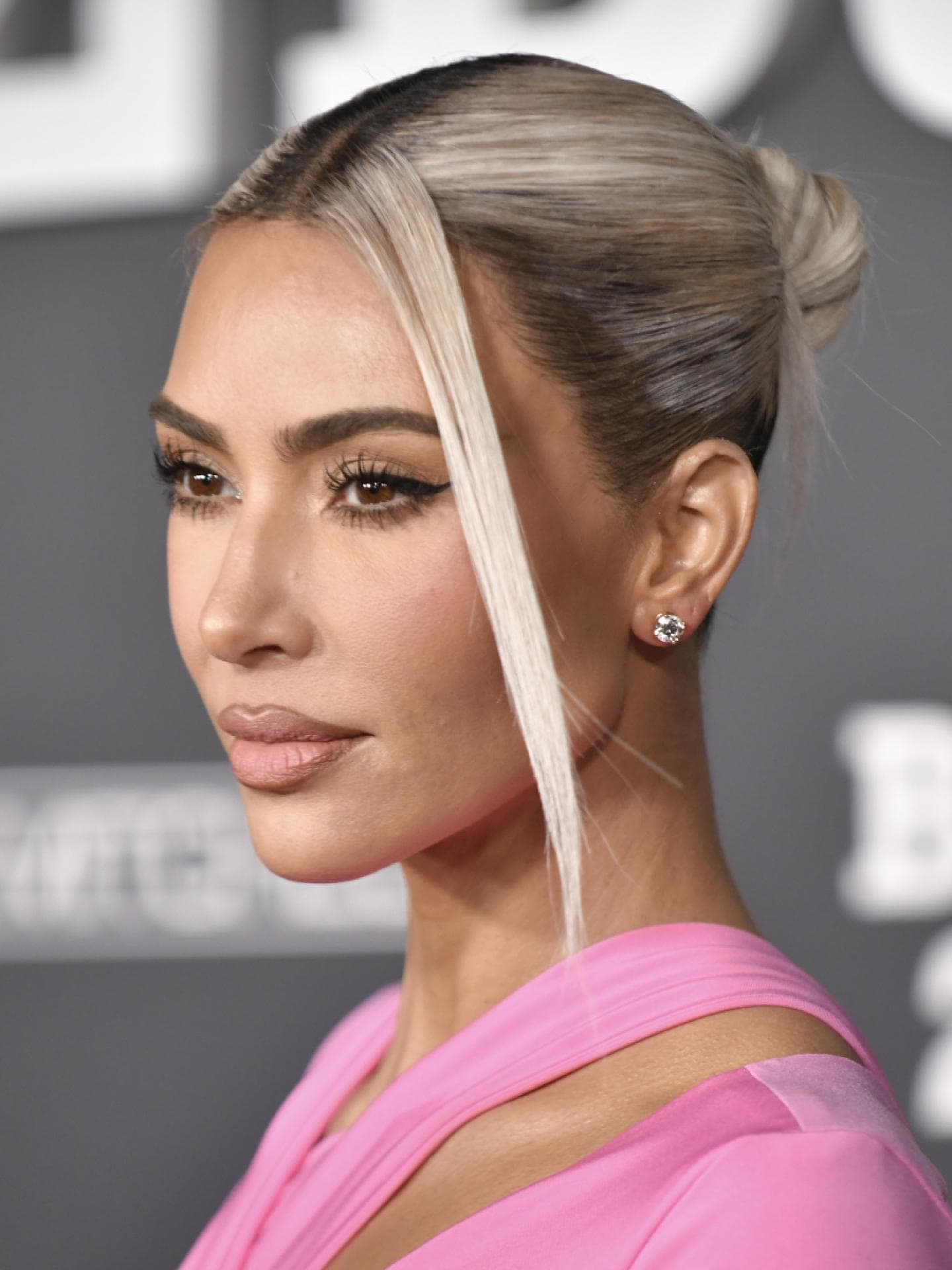 Kim Kardashian Red Carpet blonder Dutt zwei Strähnen Make-up pinkes Kleid
