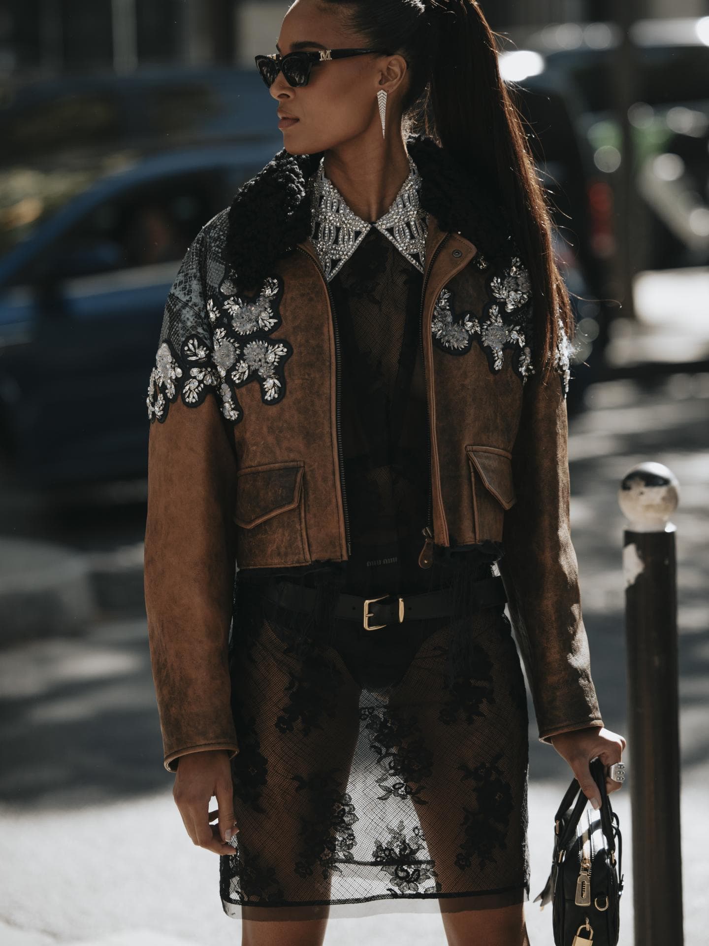 Frau trägt Spitzen Kleid Lederjacke Sonnenbrille Tasche Streetstyle