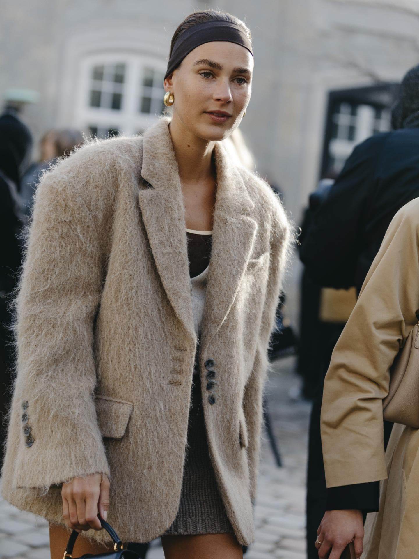 Frau trägt Blazer tasche haarband zopf
