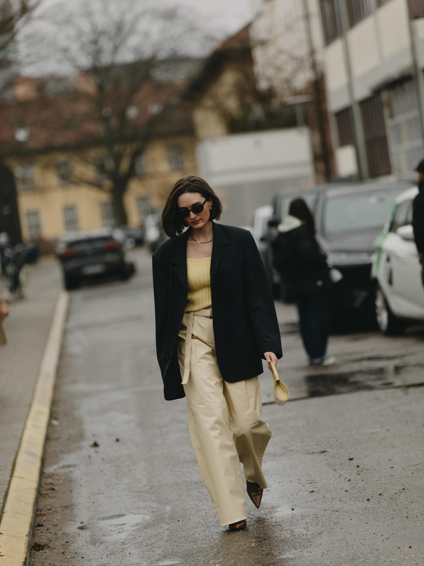 Frau trägt Oversize Blazer in schwarz weite Hose in Creme Frau trägt Oversize Blazer in schwarz weite Hose in Creme