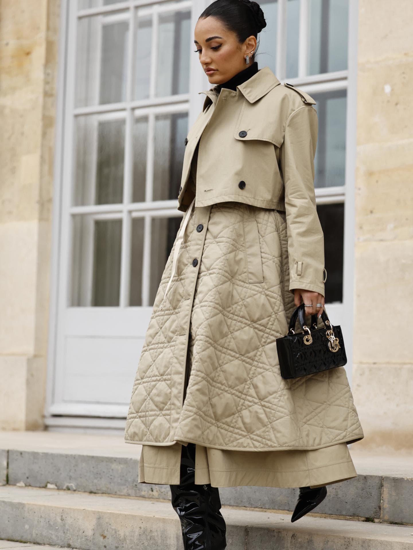 Frau trägt Stepprock beige mit Trenchcoat und schwarzen Heels