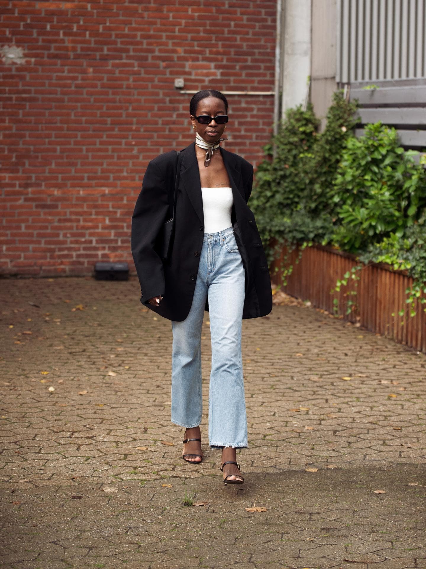 Eine Frau trägt eine blaue Jeans und einen schwarzen Blazer