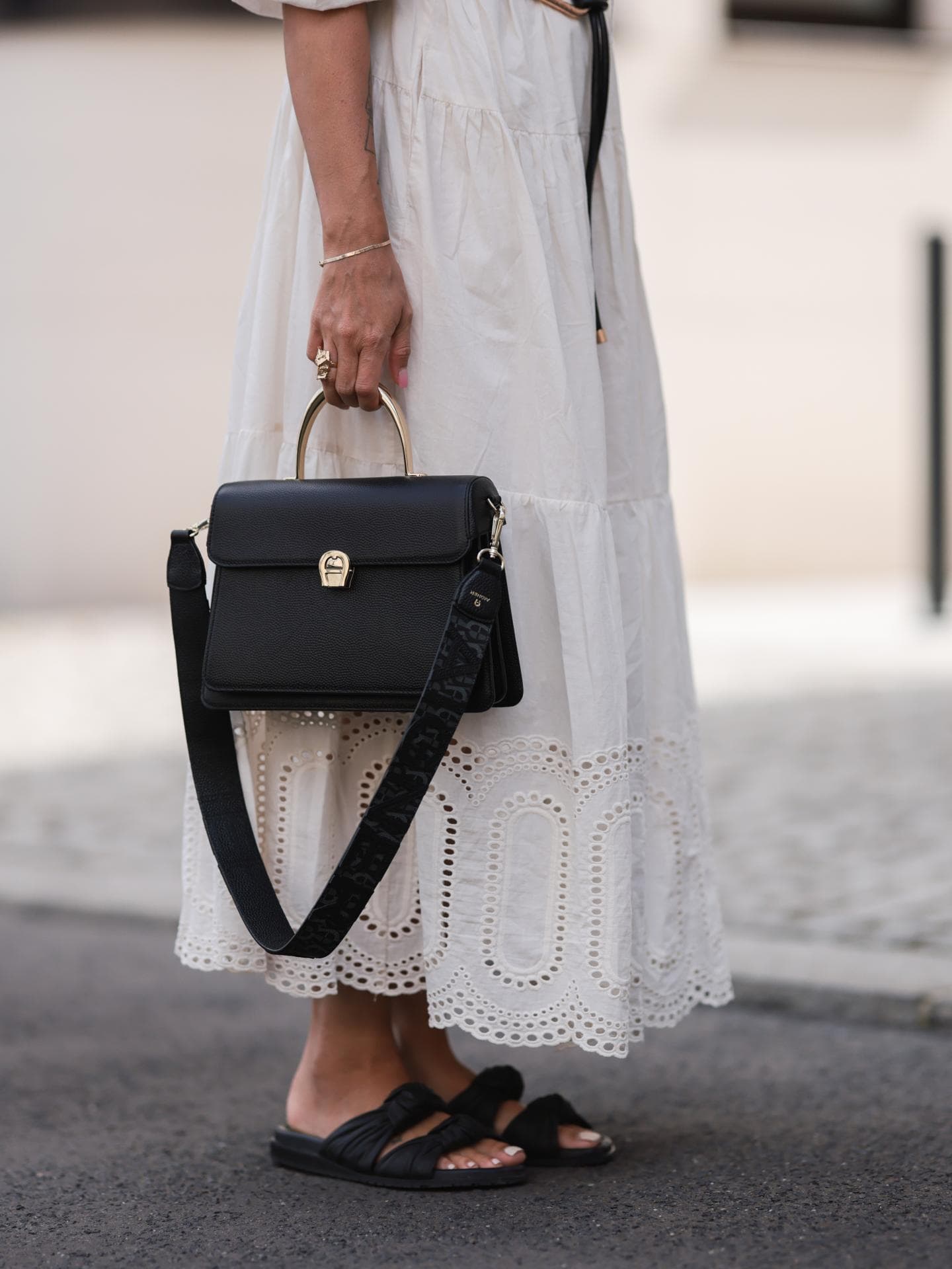 Eine Frau trägt ein weißes Kleid und schwarze Sandalen