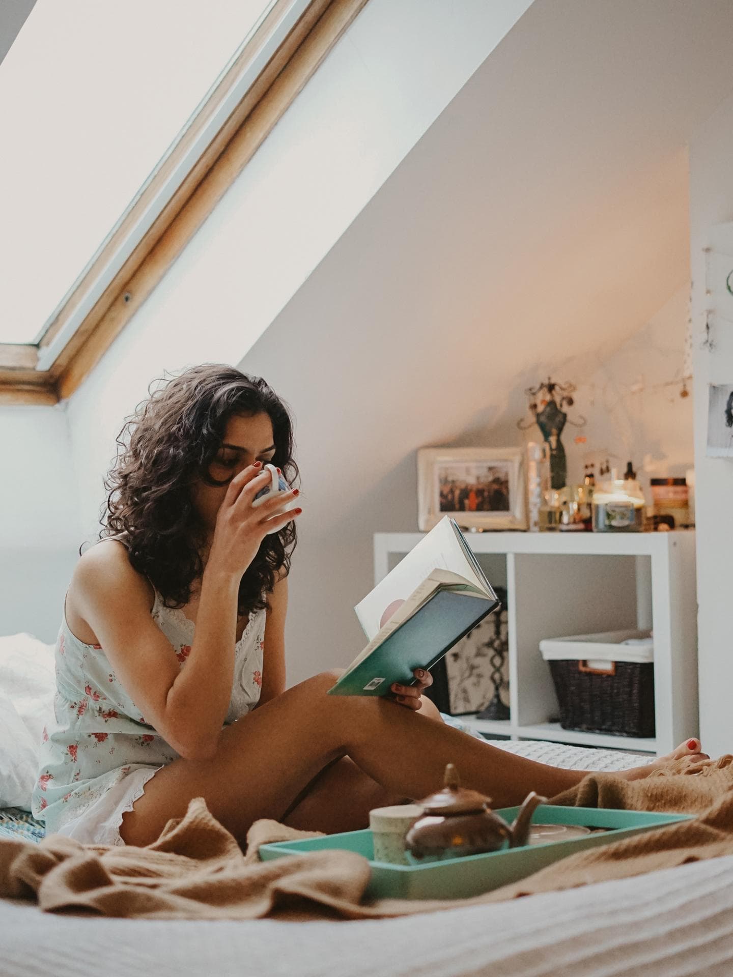 Frau liest Buch mit Kaffee in der Hand