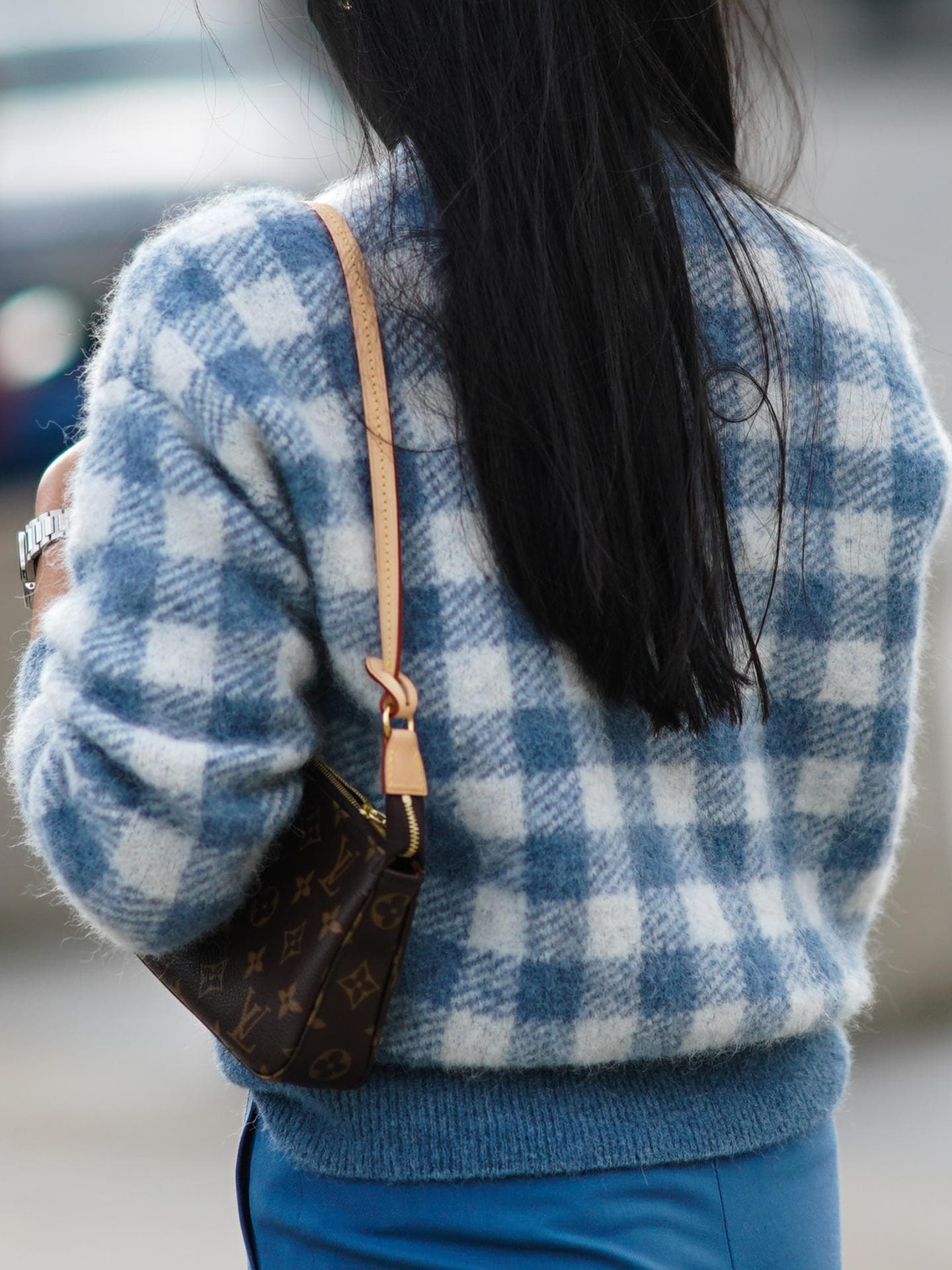 Eine Frau trägt eine Louis Vuitton Monogram Pochette Tasche