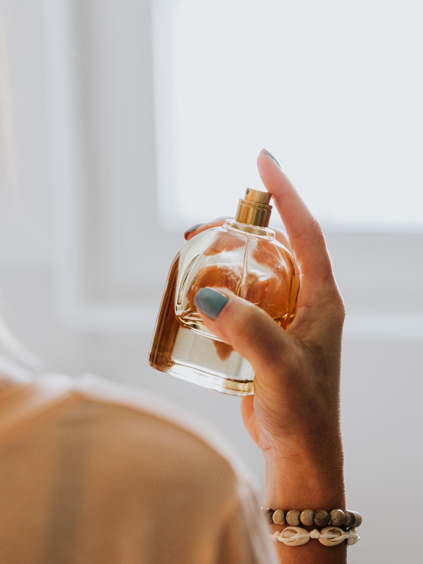 Frau hält Parfum in der Hand
