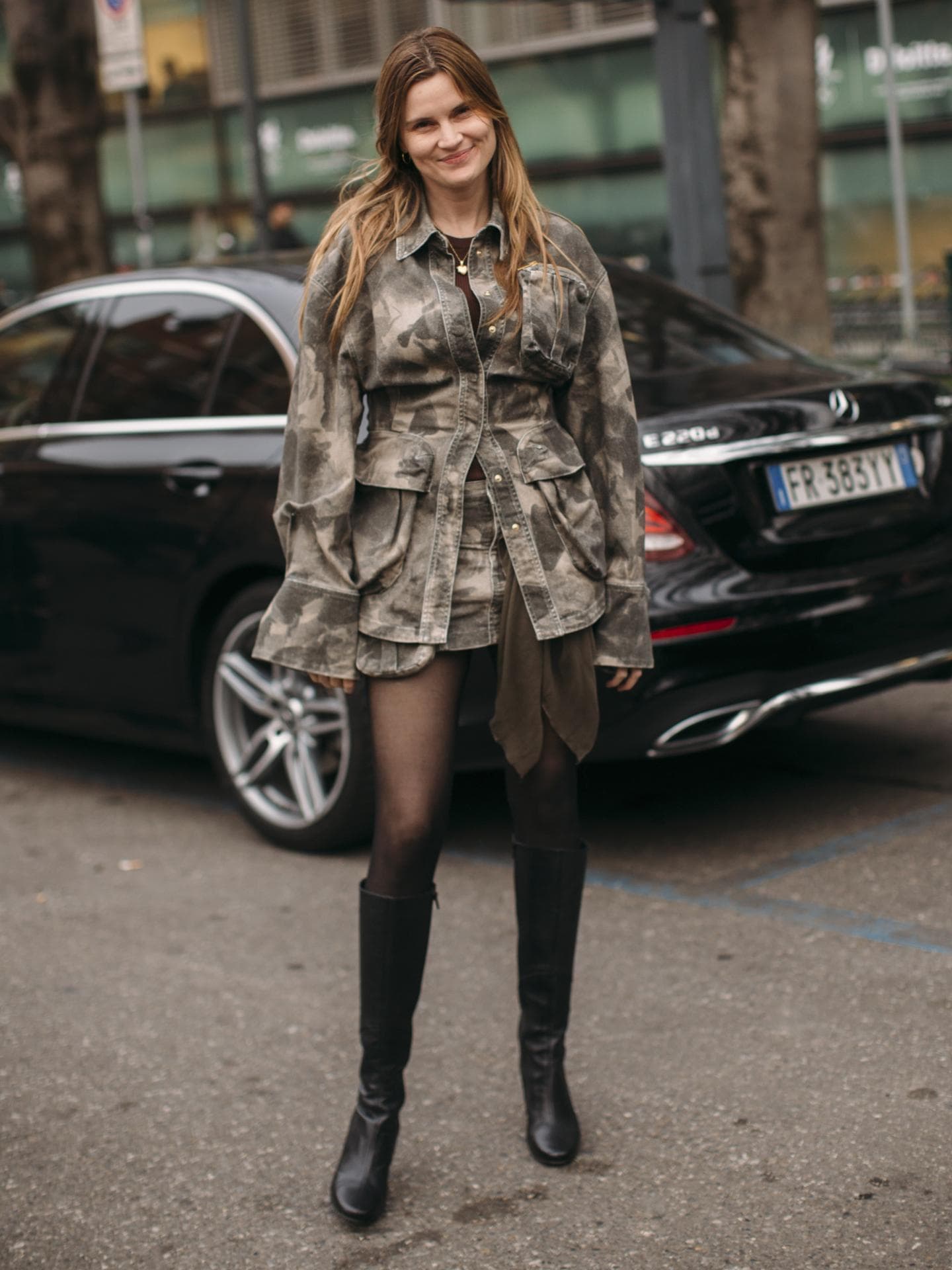 Frau trägt auf Mailand Fashion Week schwarze Stiefel kniehoch