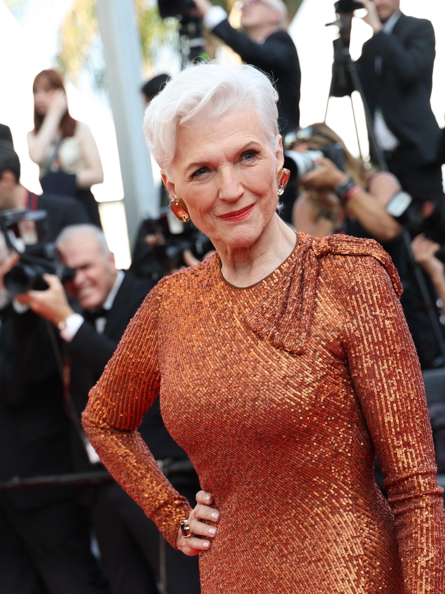 Maye Musk auf den Cammes Filmfestspielen mit grau weißen Haaren und bronzefarbenen Kleid kurze Haare Festliche Kleidung für Damen ab 60