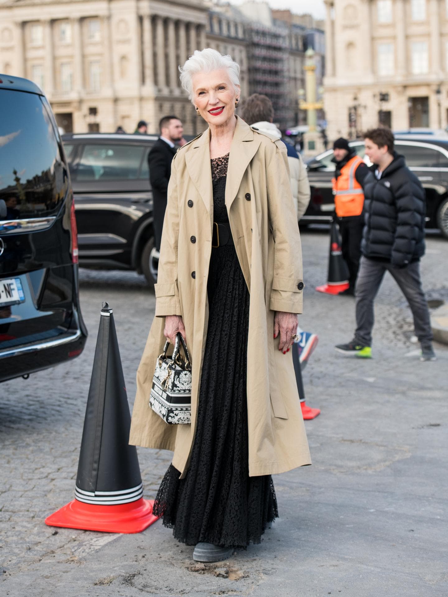 Maye Musk auf Dior Show 2023 mit beigem Trenchcoat und schwarzem Kleid Streetstyle lässige Kleidung für Frauen ab 60