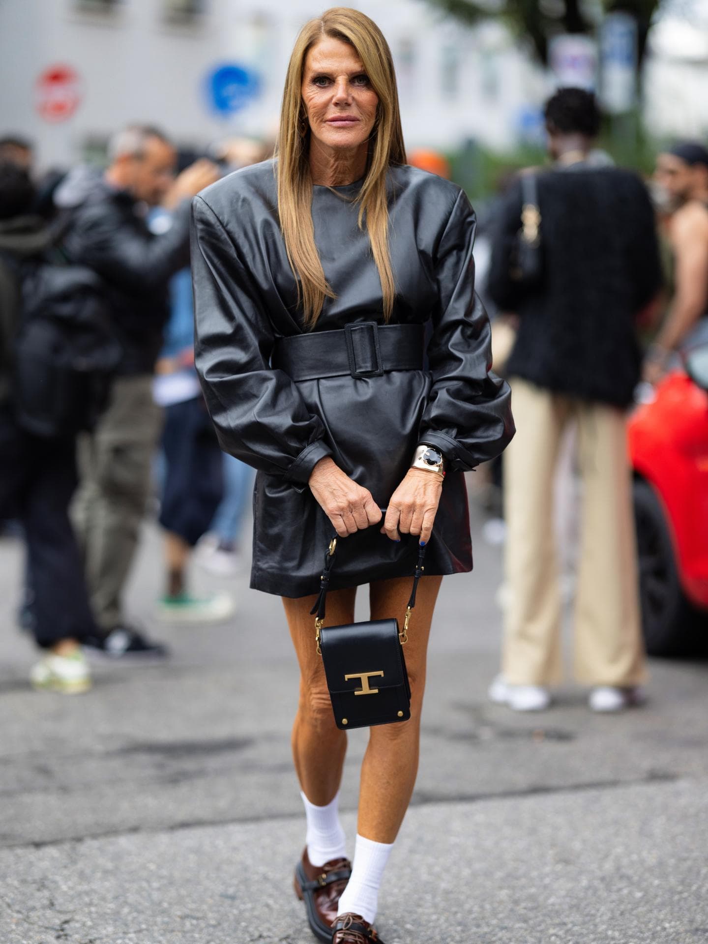 Anna dello Russo trägt schwarzes Lederkleid mit Loafern und weißen Socken