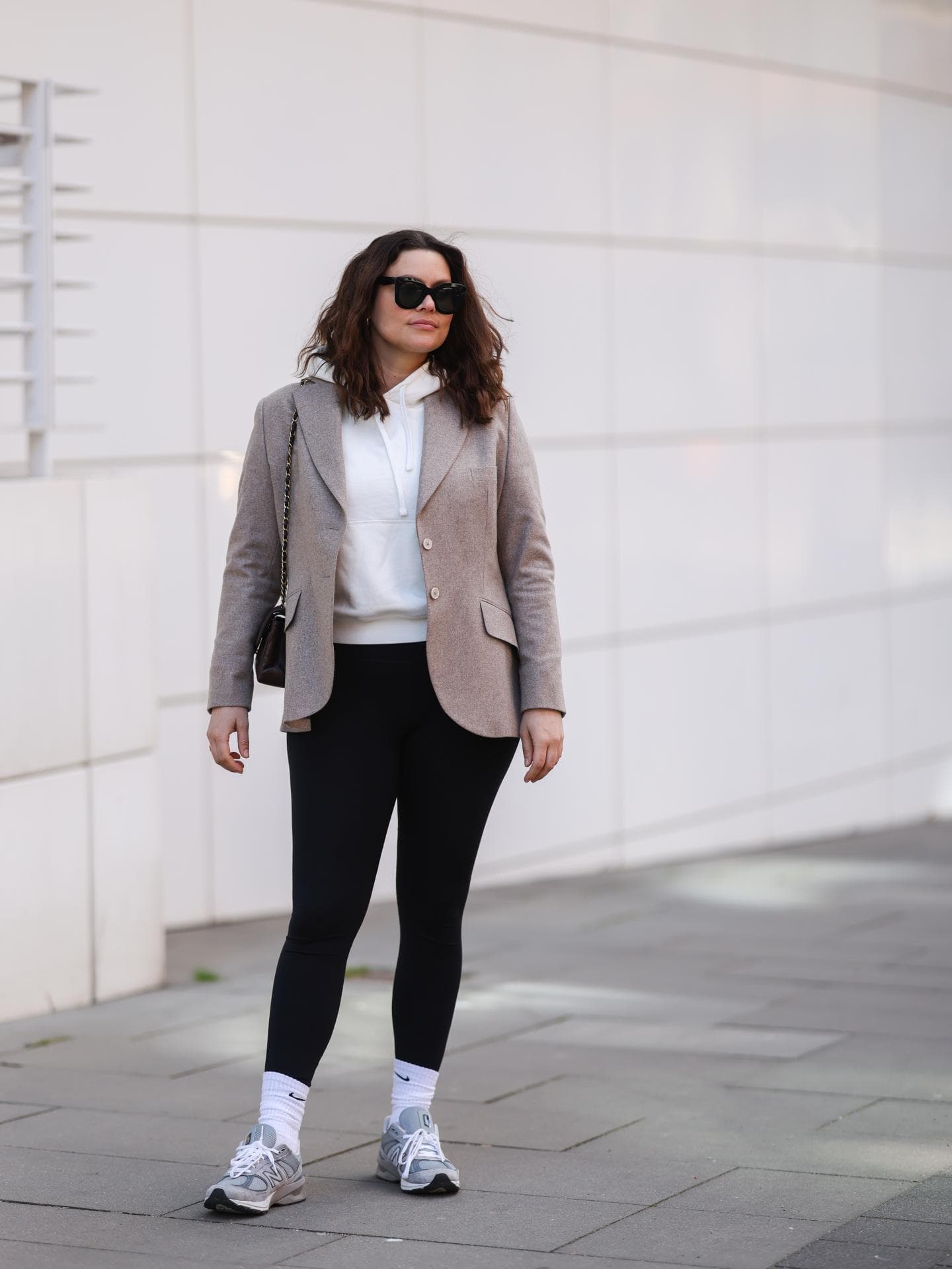 Dayami Candebat trägt schwarze Leggings mit Blazer und weißem Hoodie