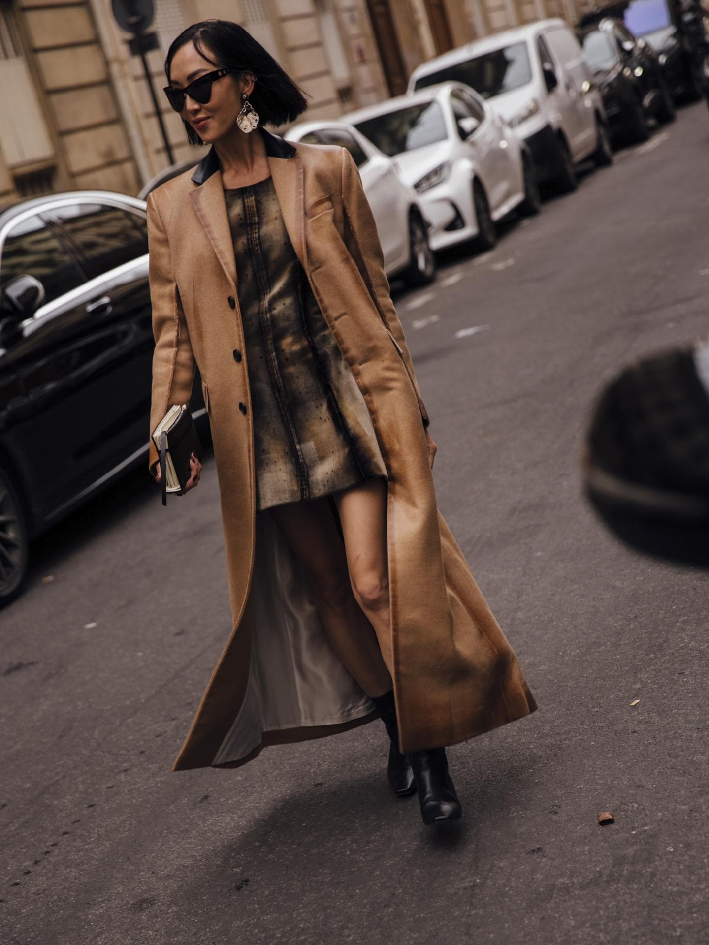 Frau trägt auf Paris Fashion Week Minikleid mit braunem Ledermantel und Boots