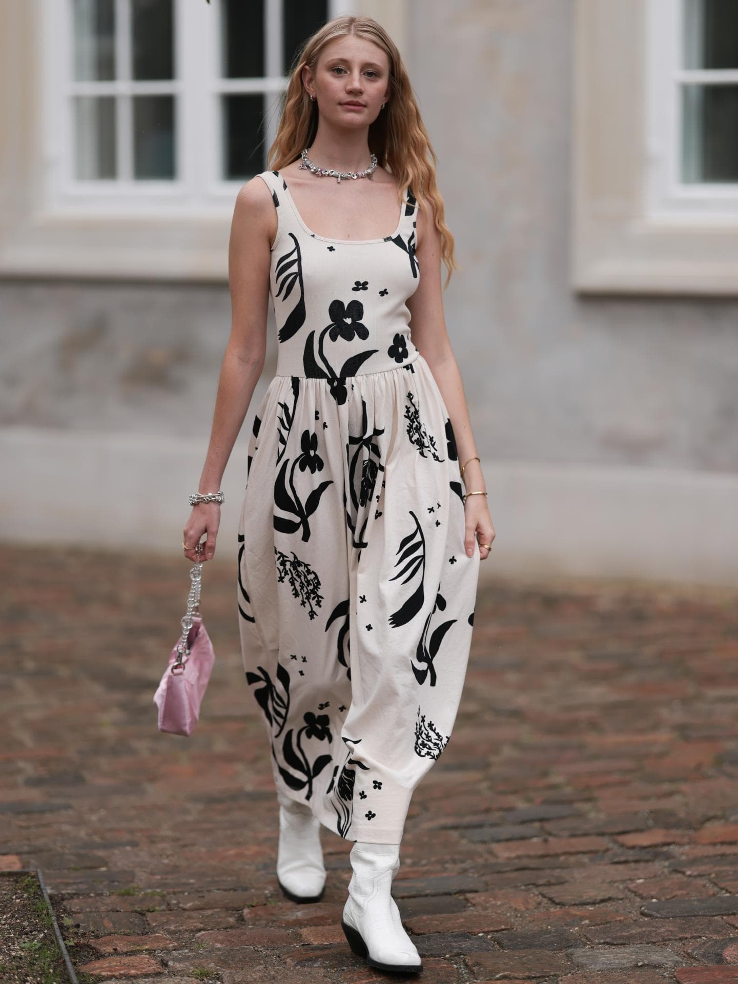 Frau trägt Kleid mit Blumenprint und weiße Stiefel