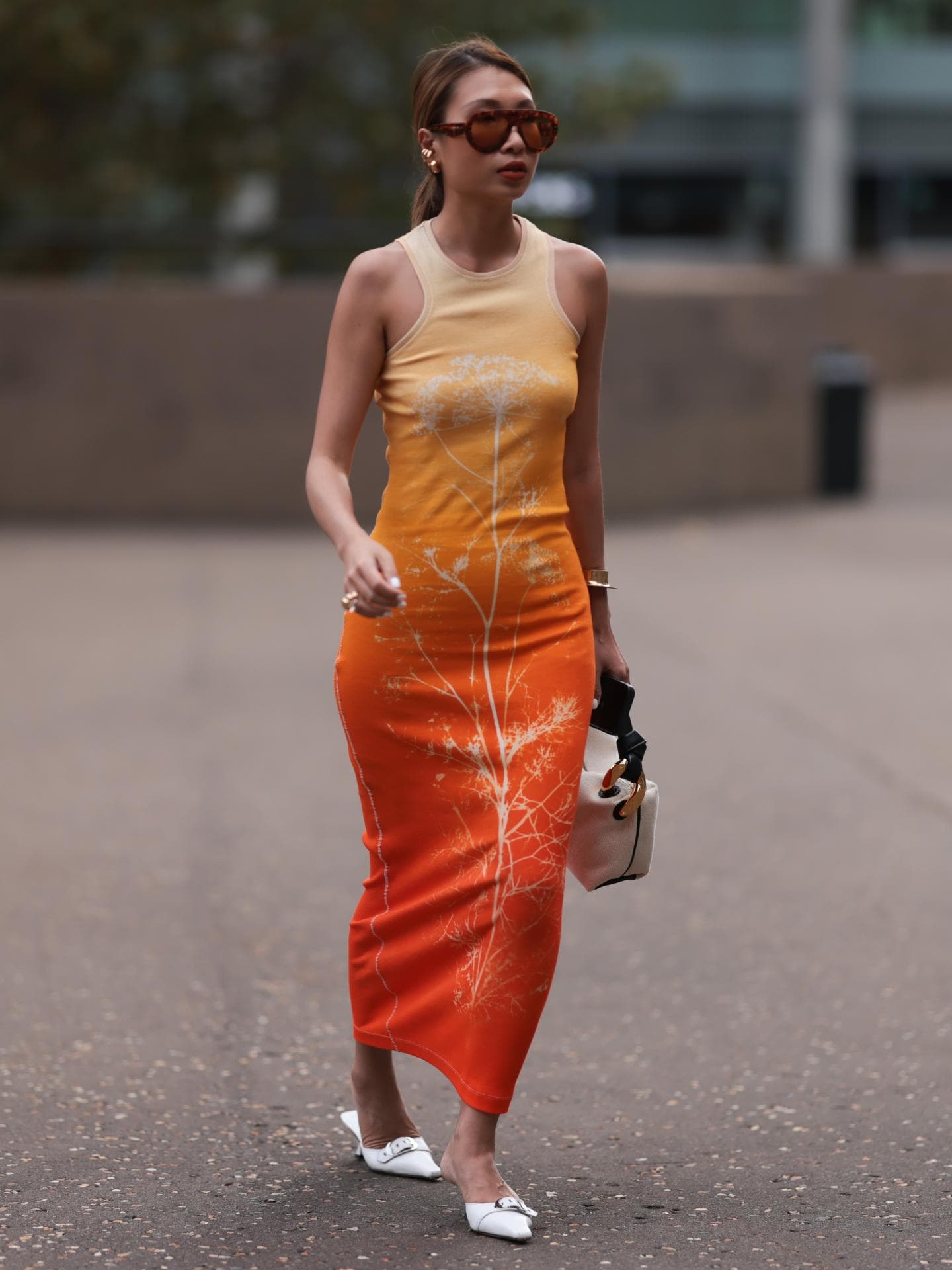 Frau trägt Mules zu orangenem Kleid Frau trägt Mules zu orangenem Kleid