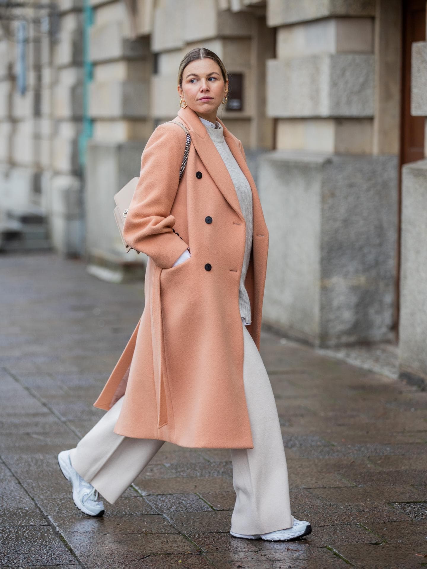 Frau trägt pfirsichfarbenen Trenchcoat Frau trägt pfirsichfarbenen Trenchcoat