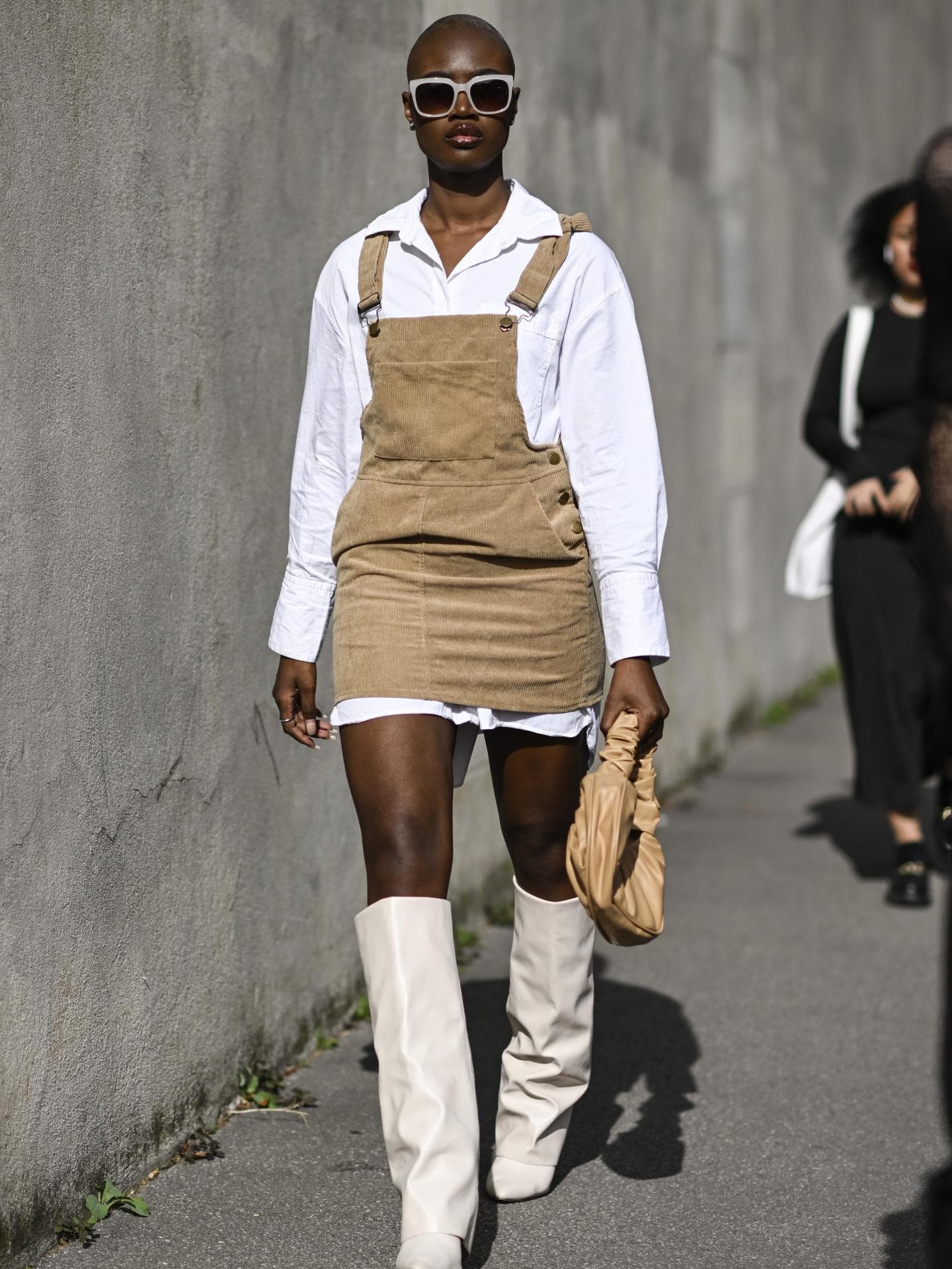 Stylische Frau trägt Minikleid aus Kord und in Latzoptik Givenchy Boots und Tasche