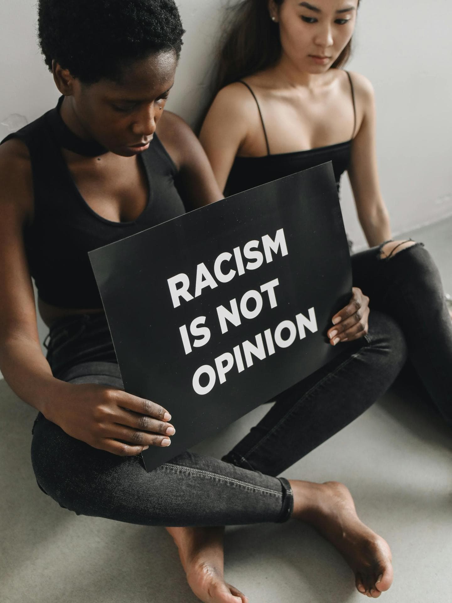 Zwei Frauen mit Schild "Racism is not opinion"
