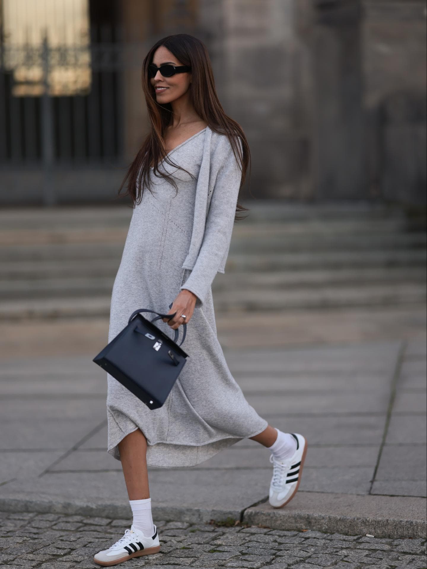 Midikleid kombinieren: So gelingt das Styling Frau in Midikleid mit Sneakern