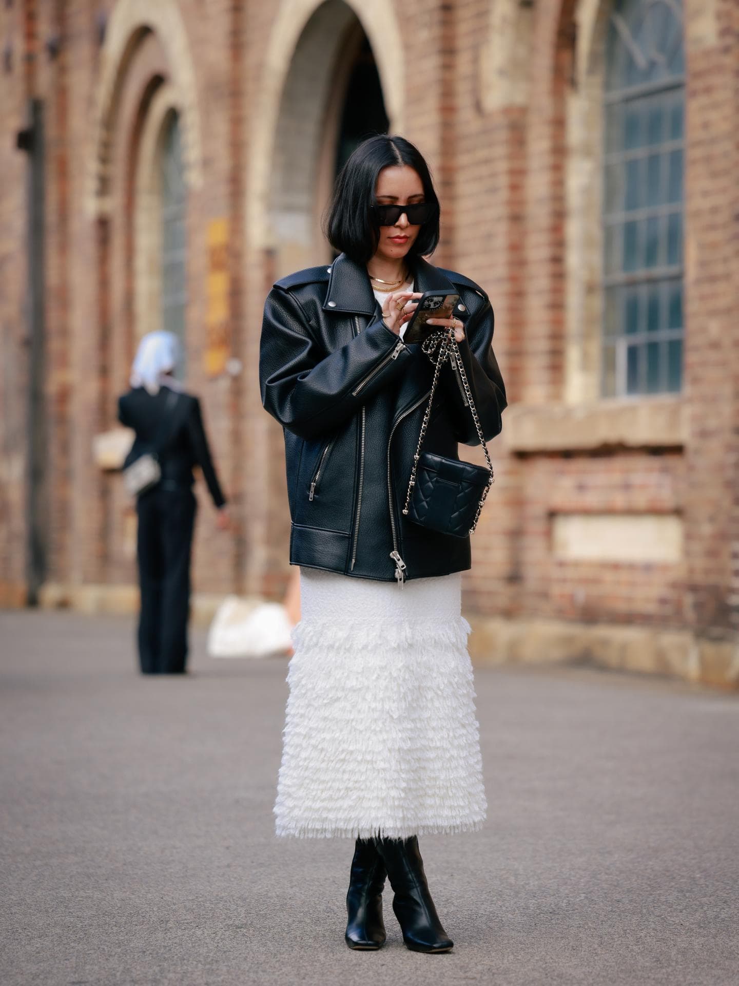 Midikleid kombinieren: So gelingt das Styling Frau trägt Midikleid mit Stiefeln