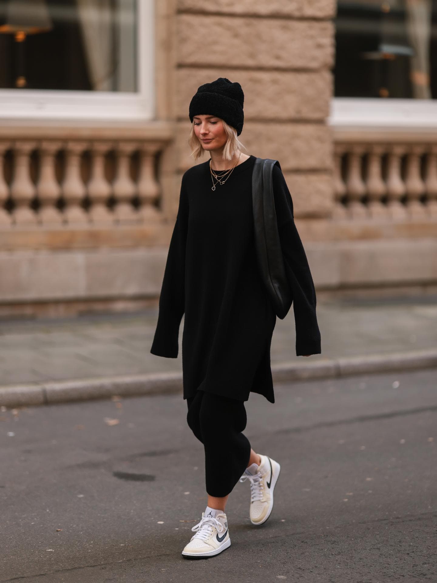 Frau in schwarzem Kleid mit Pullover