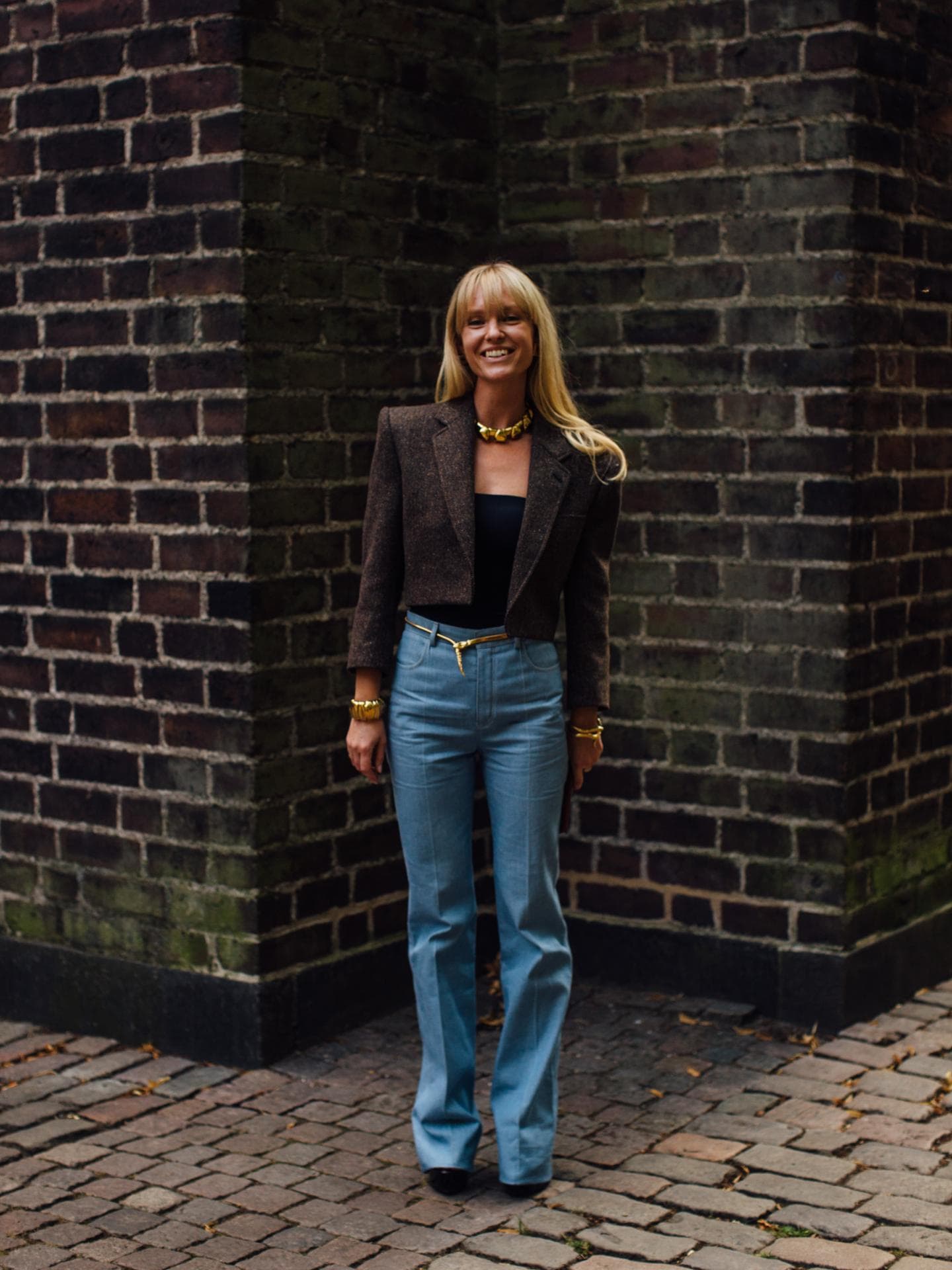 Frau trägt braunen Blazer mit blauer Hose