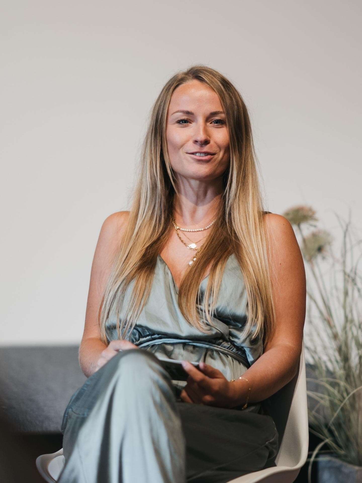 Frau mit langen blonden Haaren sitzt