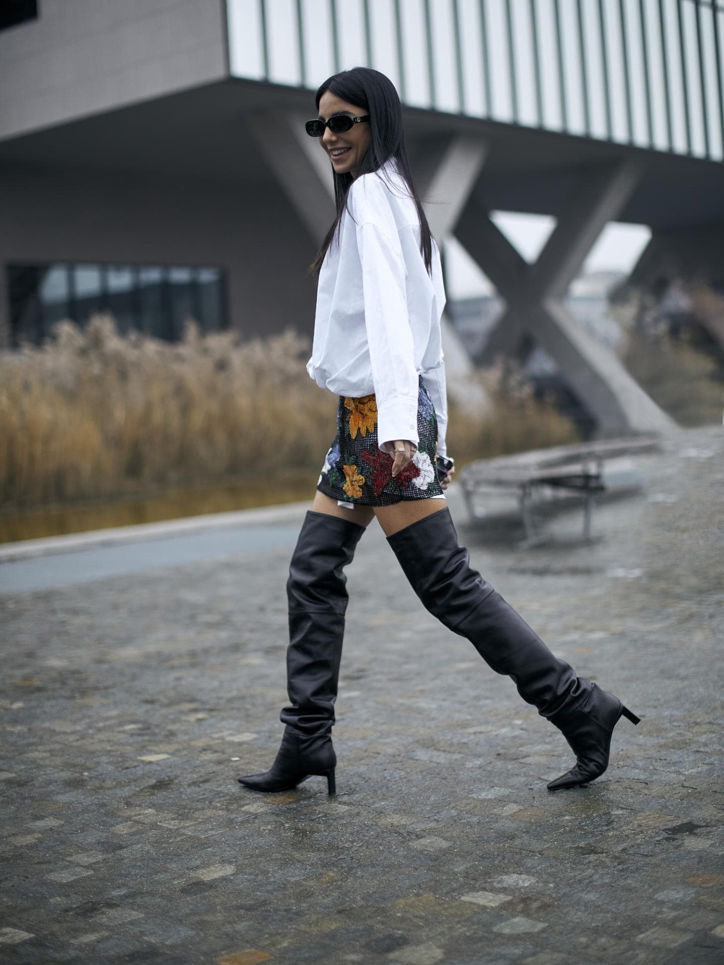 Frau stylt Overknee Stiefel mit Bluse
