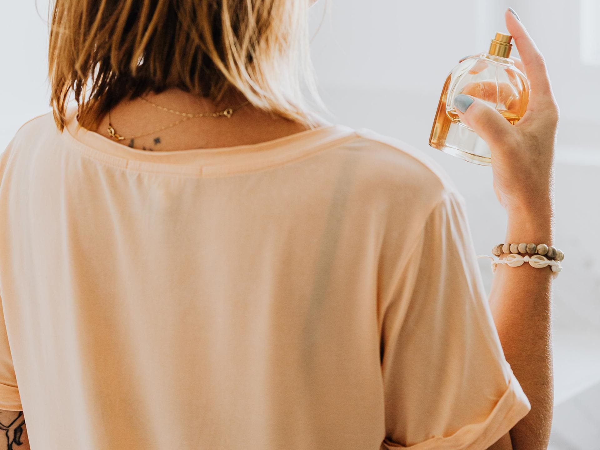 Frau sprüht Parfum auf