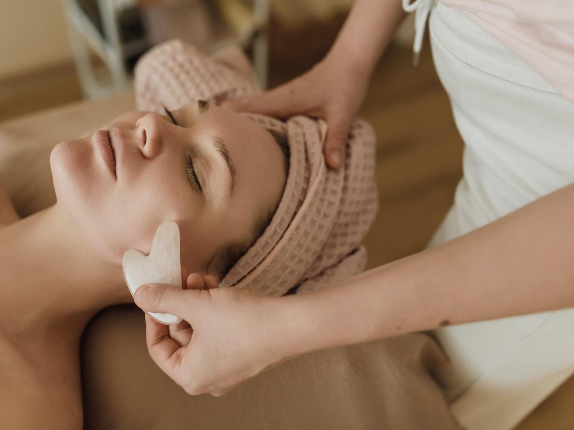 Frau bekommt eine Gua Sha Stein Anwendung