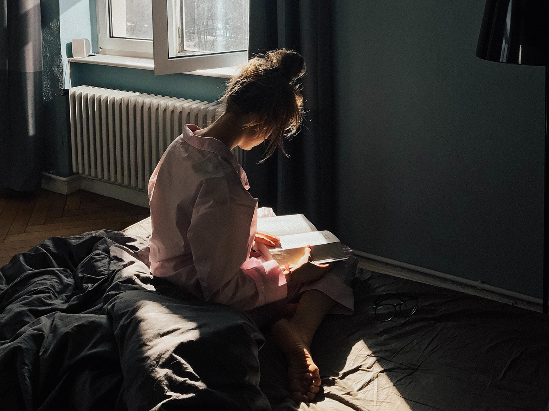 6 heiße Liebesromane Frau liest Buch auf Bett