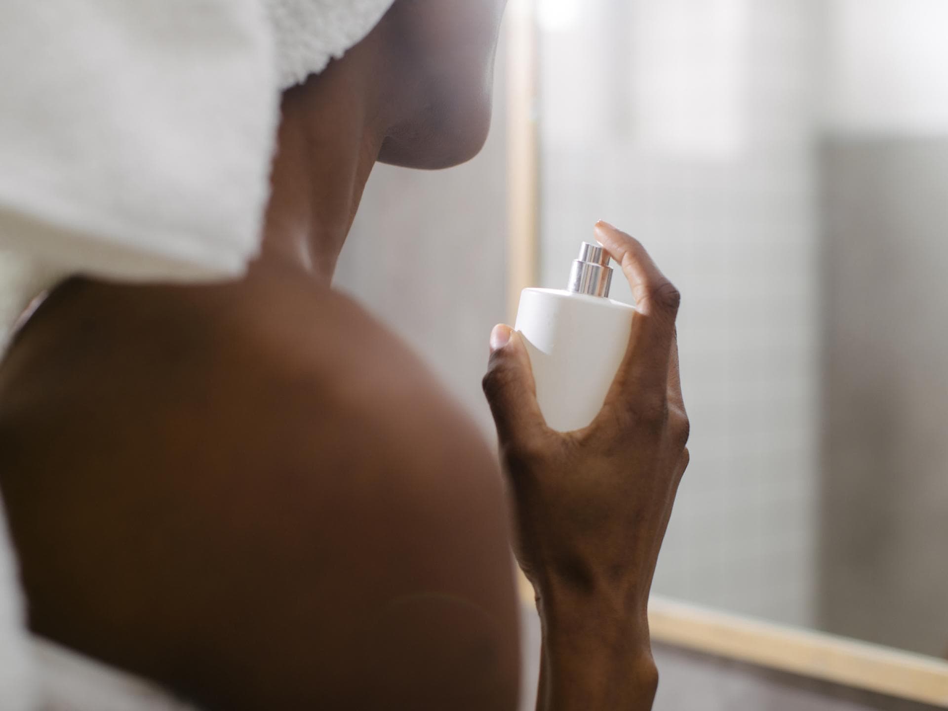 Matcha Parfums Frau sprüht sich mit Parfum ein