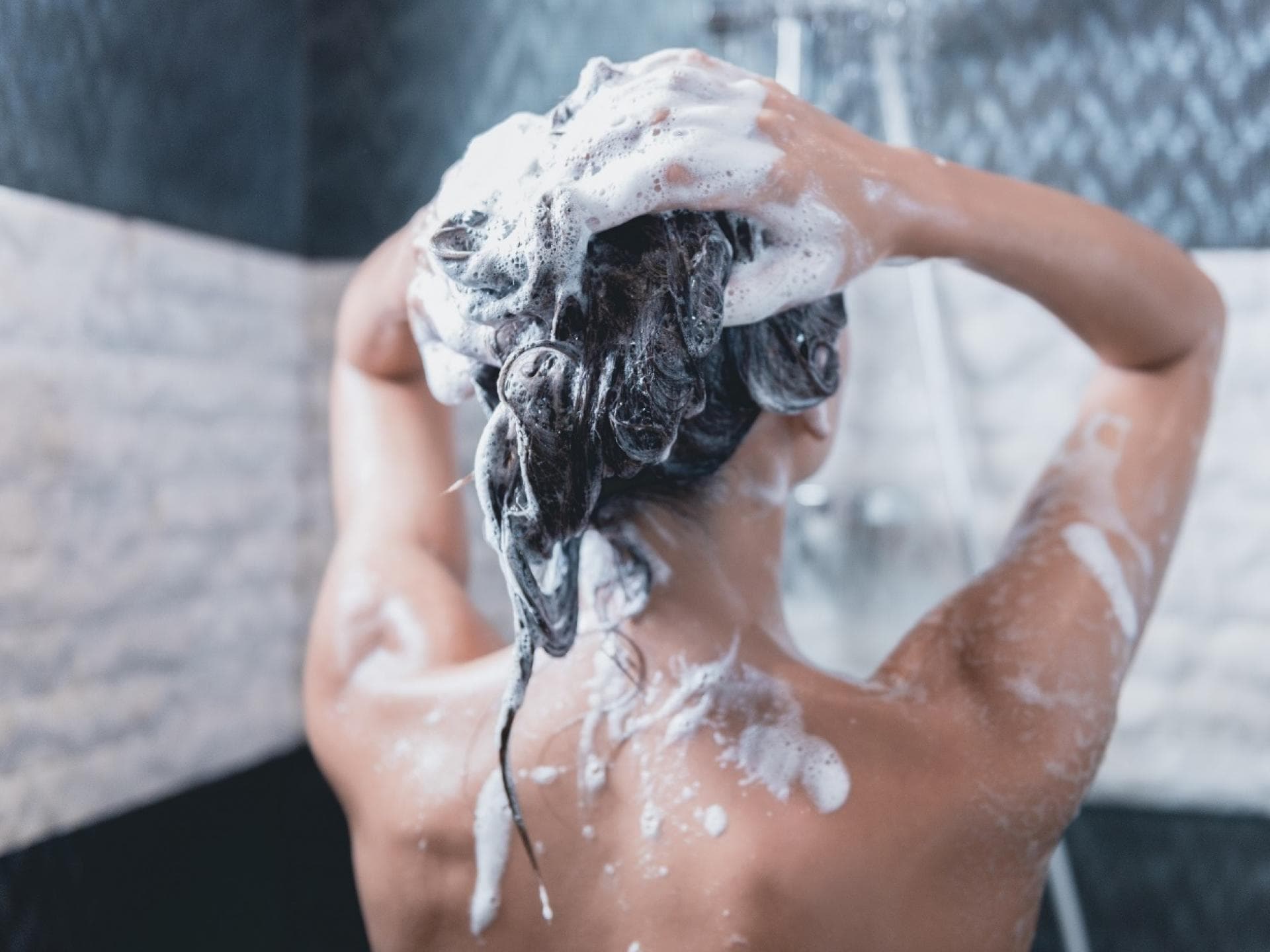 Frau wäscht sich Haare