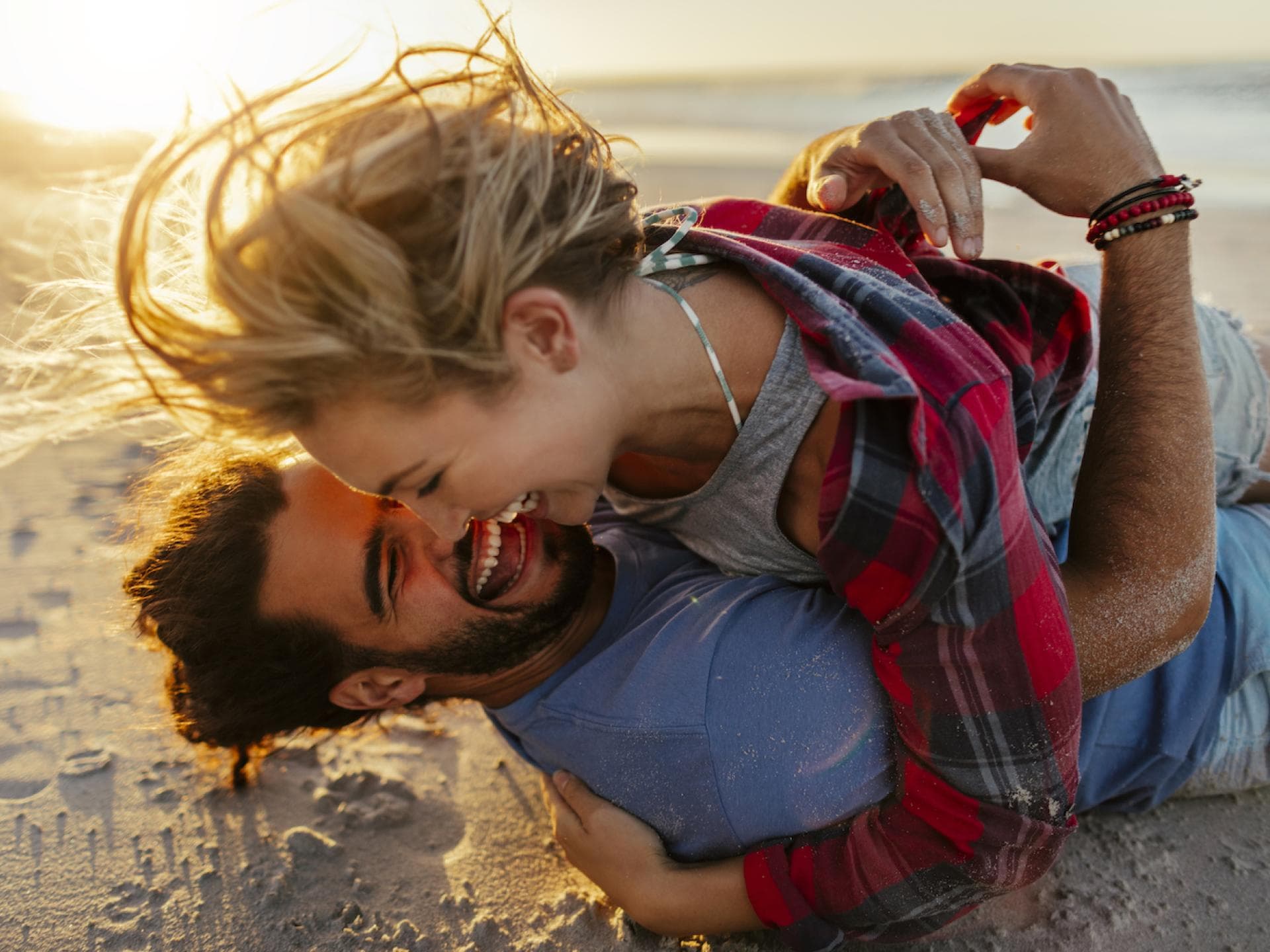 Frau und Mann lachen am Strand